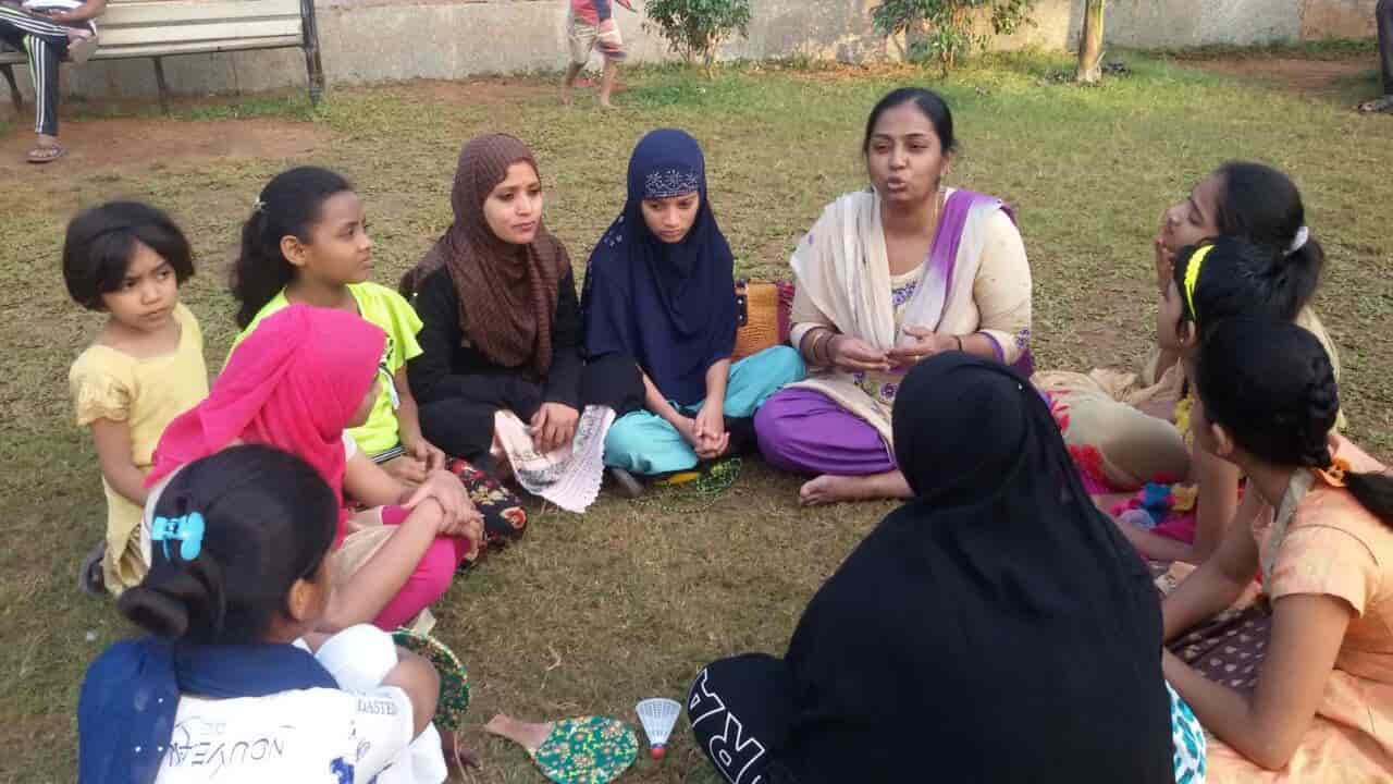 A teacher with adolescent girls  discussing their rights